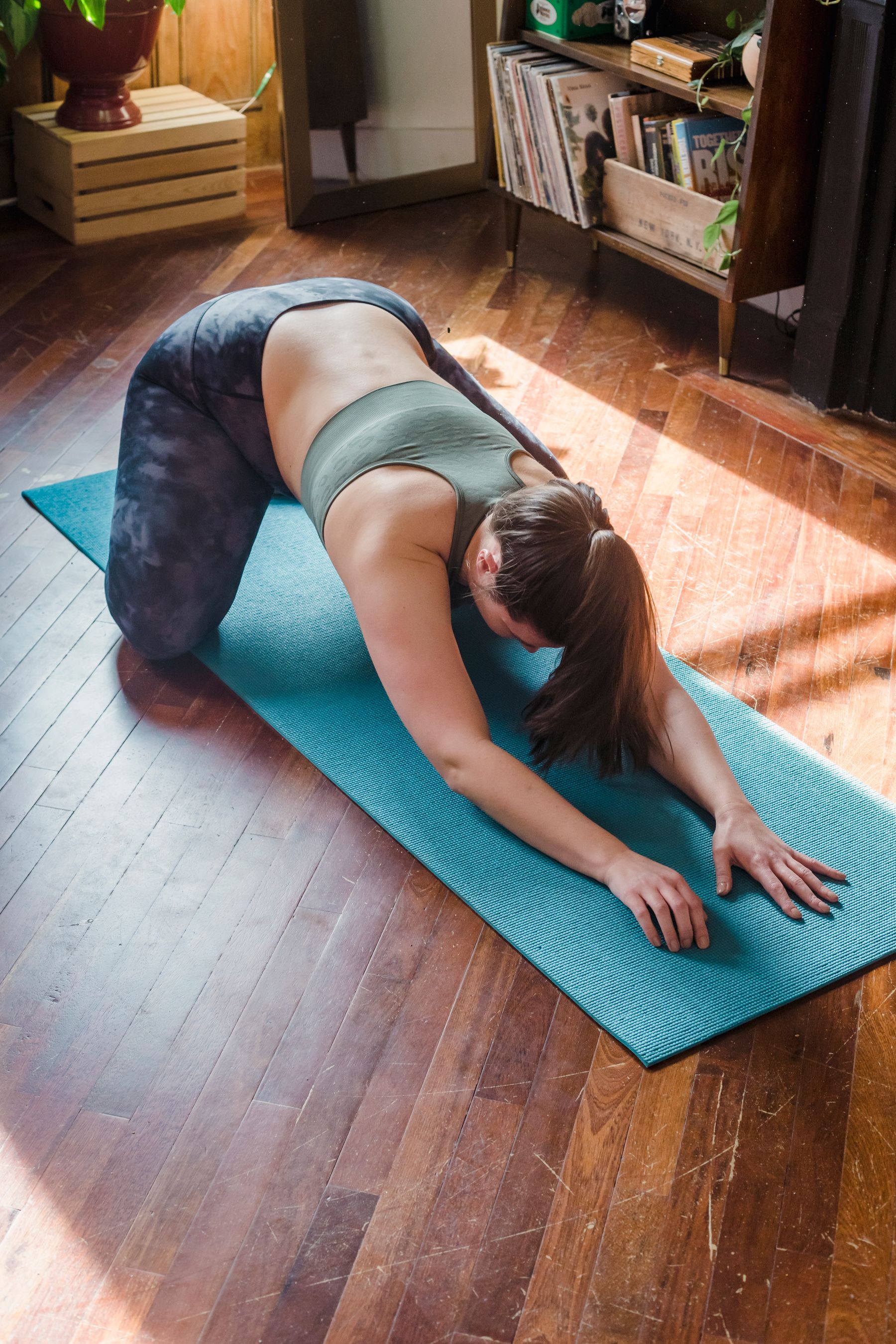 A woman practising gentle movement in a bright home